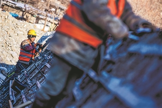 1月3日，房山區(qū)，工人正在雙泉河修筑堤壩。