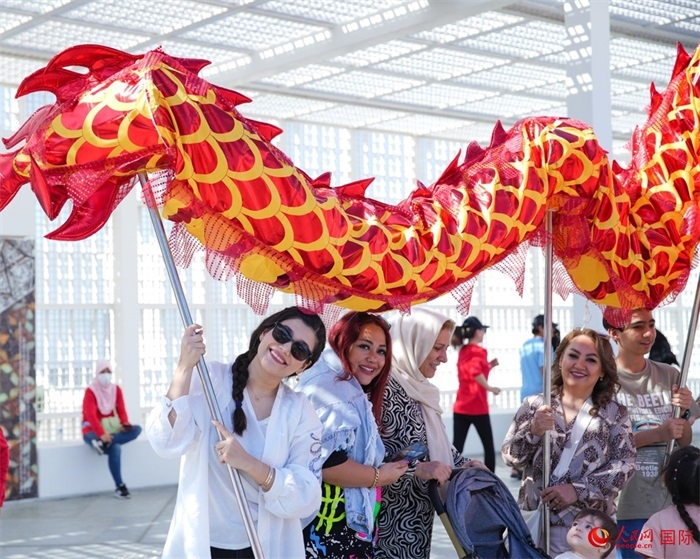 游客體驗(yàn)舞龍。 人民網(wǎng) 塔里克·易卜拉欣攝