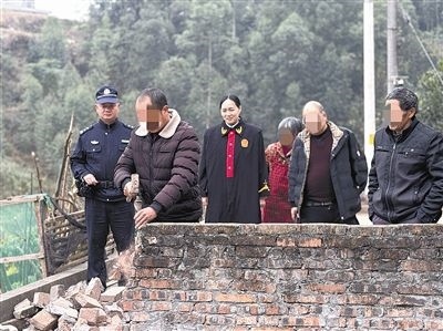  圖③：庭審結(jié)束后，在法官的見證下，陳某在院壩邊重新開鑿一條通道。