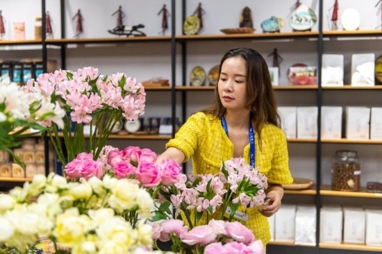 2023年7月1日，在位于湖南省長沙市的湖南高橋大市場，中非經(jīng)貿博覽會常設展館展區(qū)肯尼亞館工作人員在整理產自非洲的鮮花。新華社記者 陳思汗 攝