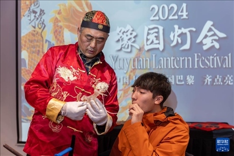 1月28日，在上海豫園舉行的民俗活動上，美國馬斯卡廷中學(xué)學(xué)生在非遺傳承人的指導(dǎo)下吹糖偶。 新華社記者 王翔 攝
