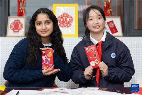 1月28日，美國馬斯卡廷中學(xué)學(xué)生（左）和復(fù)旦大學(xué)第二附屬學(xué)校學(xué)生展示互相送出的寫有寄語祝福的紅包。 新華社記者 王翔 攝