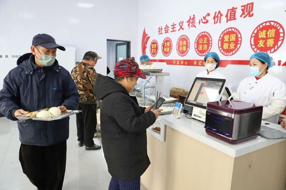 △2024年2月1日，市民在河北涿州市雙塔街道永濟秀園小區(qū)便民食堂內(nèi)購買午餐。