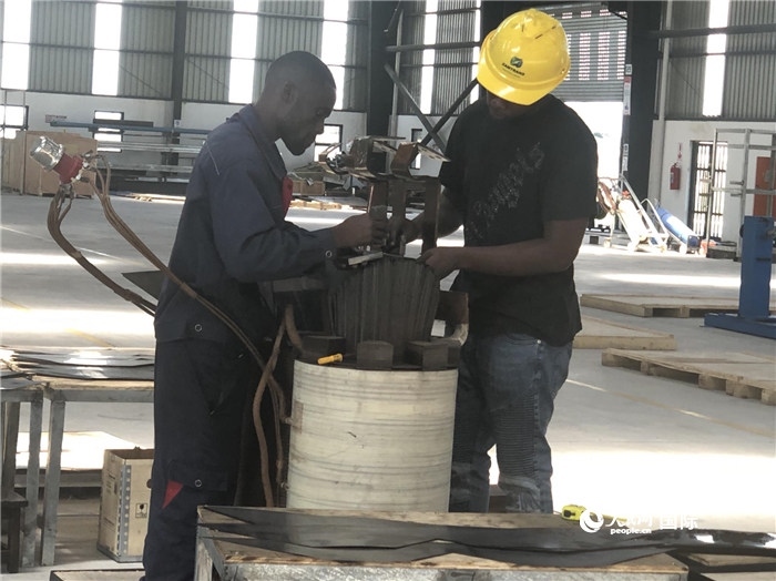 經(jīng)貿(mào)合作區(qū)廠房?jī)?nèi)，當(dāng)?shù)毓と苏诰o張作業(yè)。人民網(wǎng)記者 黃培昭攝