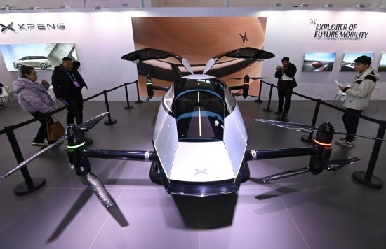 2023年12月1日，在鏈博會智能汽車鏈展區(qū)小鵬汽車展臺，參觀者觀看一臺智能飛行器。新華社記者蔡湘鑫攝