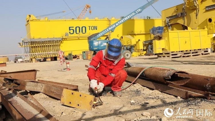 工人正在龍門(mén)吊吊裝現(xiàn)場(chǎng)切割金屬件。人民網(wǎng)記者管克江攝