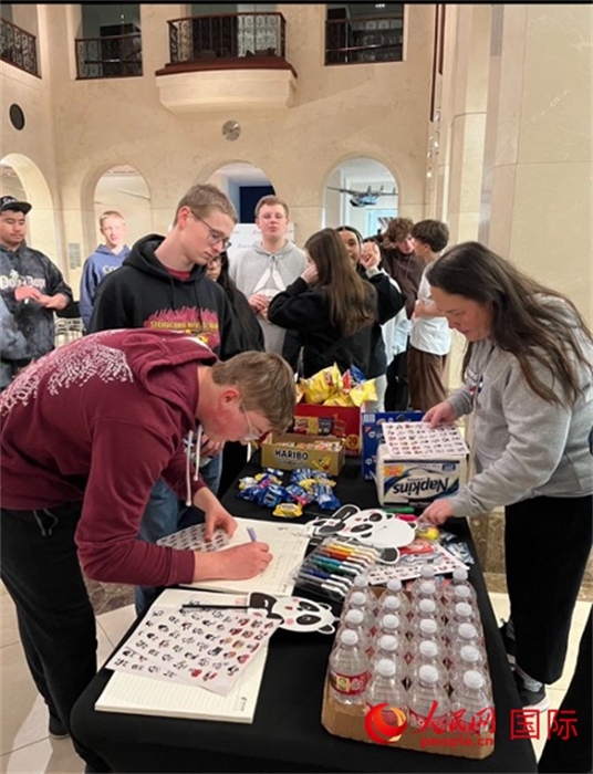 學(xué)生們出發(fā)前紛紛在留言簿留言。人民網(wǎng)記者 鄧圩攝