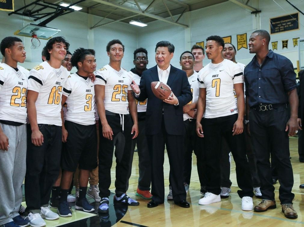 2015年9月23日，國家主席習(xí)近平參觀美國塔科馬市林肯中學(xué)。這是習(xí)近平在學(xué)校體育館，同上橄欖球訓(xùn)練課的學(xué)生們親切交談。新華社記者 蘭紅光 攝