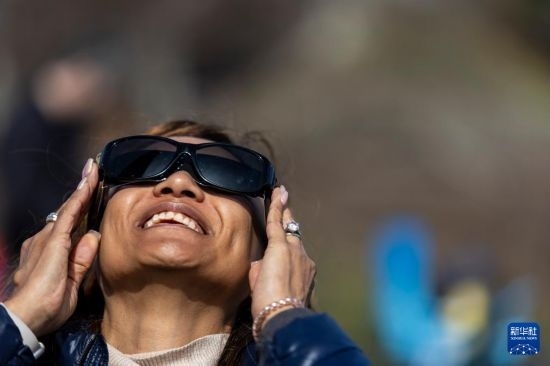 4月8日，一名女子在美國(guó)紐約州普拉茨堡觀看日食。新華社發(fā)（文森特·約翰遜攝）