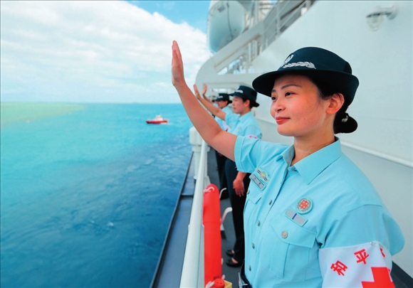 中國海軍“和平方舟”號醫(yī)院船結(jié)束訪問湯加時，任務(wù)官兵中的文職人員向歡送人群揮手告別（2023年8月4日攝）。徐巍攝/本刊