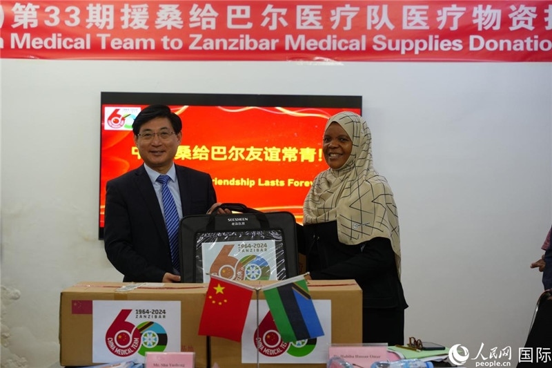 江蘇省蘇北人民醫(yī)院黨委書記束余聲捐贈(zèng)物資與桑衛(wèi)生部首席秘書哈比巴。中國(guó)援桑醫(yī)療隊(duì)供圖