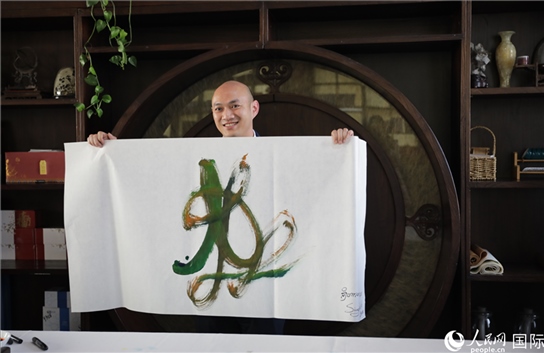 老撾駐華大使館三秘明君參加《五百筆·瀾湄合作》集體藝術(shù)創(chuàng)作。人民網(wǎng)王婧攝。