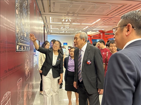 工作人員為泰國前副總理、泰中文化促進委員會主席披尼講解展覽內容。中國駐泰國大使館供圖