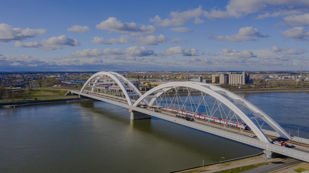 2024年3月12日，一列火車運(yùn)行在匈塞鐵路塞爾維亞境內(nèi)貝諾段諾維薩德多瑙河大橋上（無人機(jī)照片）。新華社發(fā)（任衛(wèi)云攝）