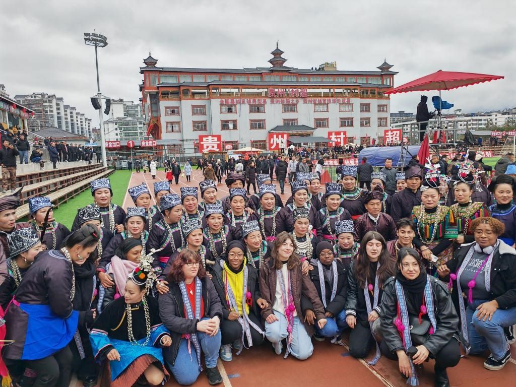 法國青年在“村超”賽場邊與參加表演的村民合影。新華社記者 羅羽 攝