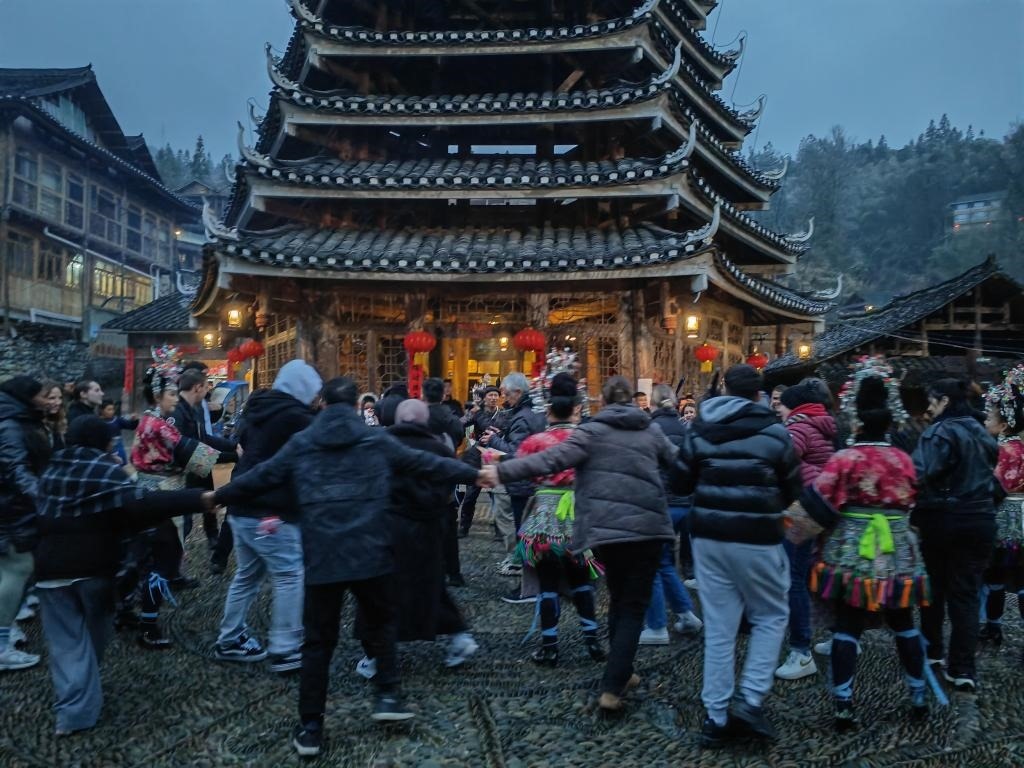 法國青年與當(dāng)?shù)卮迕駹渴痔?。新華社記者 羅羽 攝