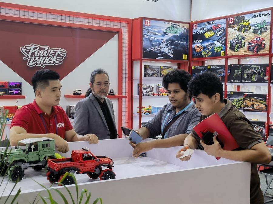 在第135屆廣交會第三期現(xiàn)場，采購商在廣東信宇科技股份有限公司展位選購、體驗積木遙控車產品（5月2日攝）。新華社記者 洪澤華 攝