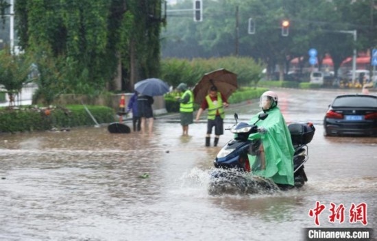 5月10日，廣西沿海遭遇強(qiáng)降雨。圖為欽州市民眾在積澇中出行。陸敏 攝