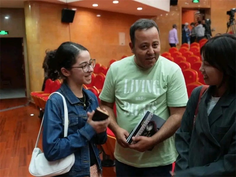 阿爾及利亞市民拉納·艾薩尼和她父親現(xiàn)場聆聽中阿交響樂演出 。蘇州交響樂團(tuán)供圖