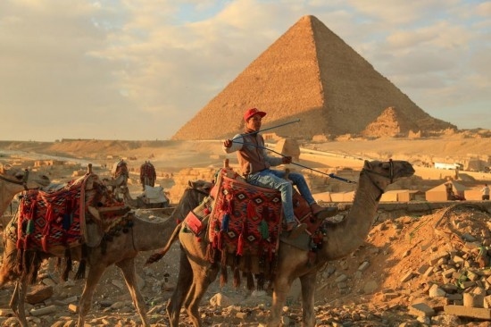 1月24日，商販騎駱駝離開埃及吉薩金字塔景區(qū)。新華社記者 隋先凱 攝