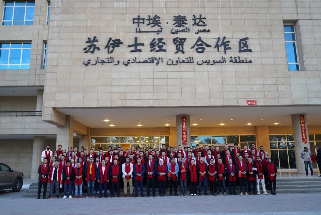 2024年2月11日，在位于埃及蘇伊士省的中?！ぬ┻_(dá)蘇伊士經(jīng)貿(mào)合作區(qū)，中埃員工在合作區(qū)辦公大樓前合影拜年。新華社發(fā)（泰達(dá)合作區(qū)供圖）