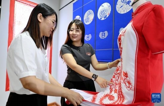 5月31日，在衡水市阜城縣一家剪紙工作室，游客在觀賞帶有剪紙?jiān)氐钠炫邸? width=