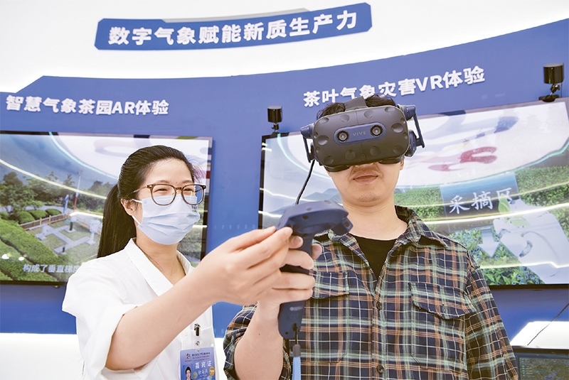 2024年5月23日，第七屆數(shù)字中國建設(shè)峰會現(xiàn)場體驗區(qū)在福州海峽國際會展中心向?qū)I(yè)觀眾開放。本次現(xiàn)場體驗區(qū)圍繞本屆峰會主題“釋放數(shù)據(jù)要素價值，發(fā)展新質(zhì)生產(chǎn)力”，設(shè)置“數(shù)字惠民”、“數(shù)字能力”、“數(shù)字基礎(chǔ)”、“數(shù)字生態(tài)”、“數(shù)字賦能”五大板塊。圖為一名觀眾（右）在數(shù)字氣象賦能新質(zhì)生產(chǎn)力展臺上進行體驗。 新華社記者 魏培全/攝