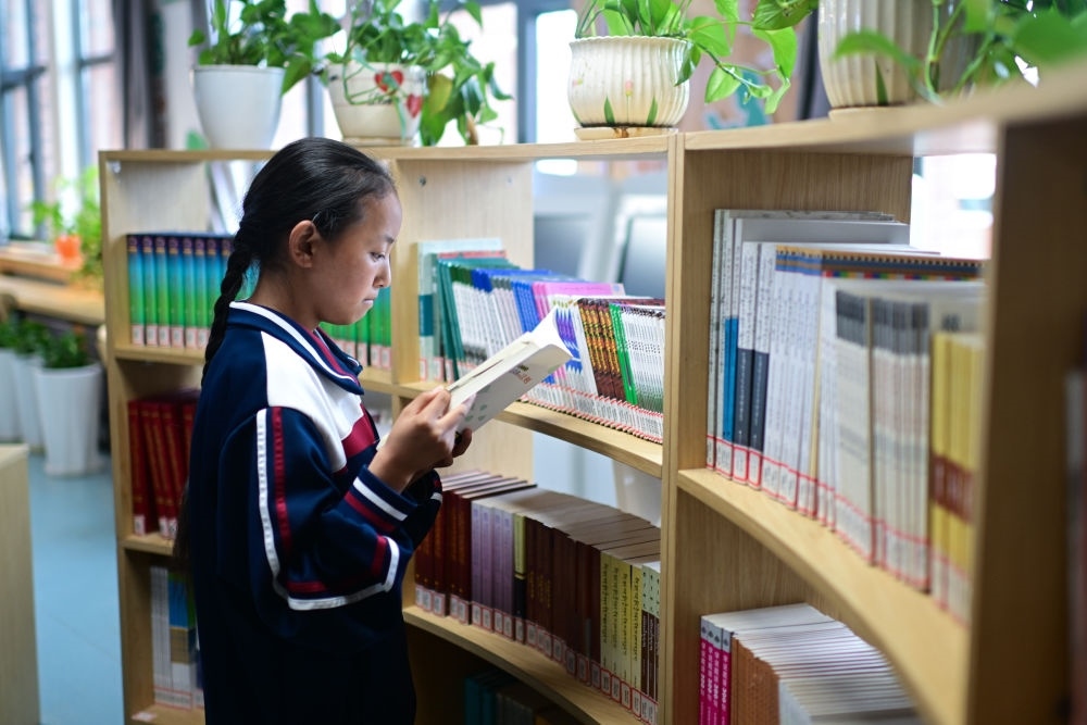 6月18日，果洛西寧民族中學(xué)學(xué)生尼東拉毛在圖書室看書。