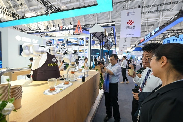 6月20日，與會(huì)者品嘗機(jī)器人沖調(diào)出的咖啡。新華社記者 孫凡越 攝