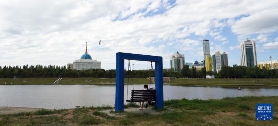 6月30日，一名女子在哈薩克斯坦首都阿斯塔納伊希姆河畔休息。新華社記者 王建華 攝