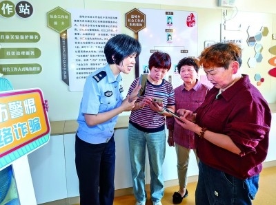 浙江湖州民警指導(dǎo)居民加入湖州“e企安”微信群，實(shí)時(shí)接收反詐信息。新華社發(fā)