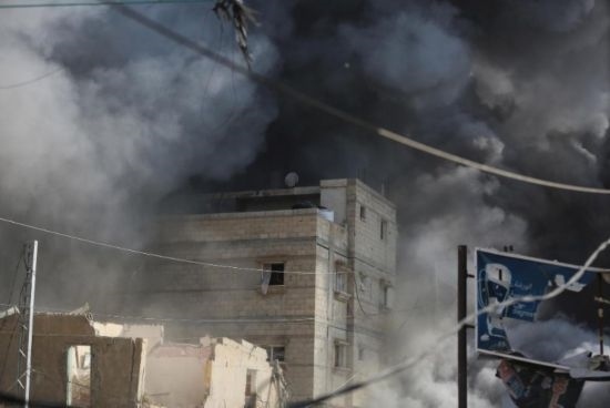 7月21日，在加沙地帶中部的努賽賴特難民營，遭以軍空襲的建筑冒出滾滾濃煙。新華社發(fā)（馬爾萬·達(dá)烏德攝）