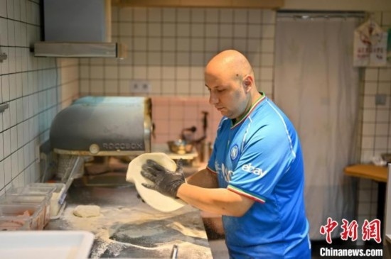 近日，韋榮耀在自家披薩小店內(nèi)忙活。俞靖 攝