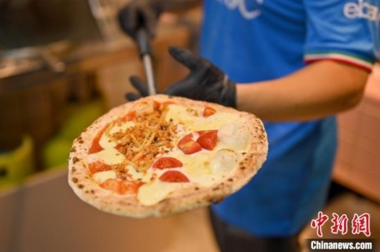 近日，韋榮耀展示他制作的“老友味”披薩。 俞靖 攝
