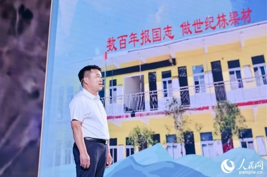 張玉滾分享用一根扁擔(dān)送孩子們走出大山的故事。人民網(wǎng)攝