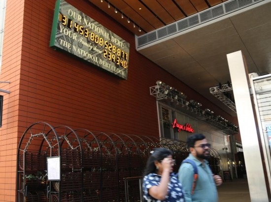 2023年5月29日，人們經(jīng)過美國紐約曼哈頓的“國債鐘”?！皣鴤姟笔且粋€大型計數(shù)器，它實時更新美國的公共債務總額，并顯示出每個美國家庭所要負擔的數(shù)額。 新華社記者劉亞南攝