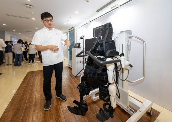 2024年5月24日，在位于上海市嘉定區(qū)的上海交通大學醫(yī)學院附屬瑞金醫(yī)院腫瘤質子中心，工作人員介紹由瑞金醫(yī)院醫(yī)生和醫(yī)療公司共同研發(fā)的用于恢復患者下肢的醫(yī)療機器人。新華社記者 王翔 攝