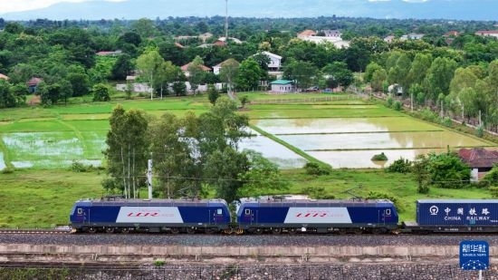 8月5日，由老撾籍火車司機(jī)獨(dú)立駕駛的滿載貨物的列車駛出萬象站，向中國昆明進(jìn)發(fā)（無人機(jī)照片）。新華社發(fā)（楊永全 攝）