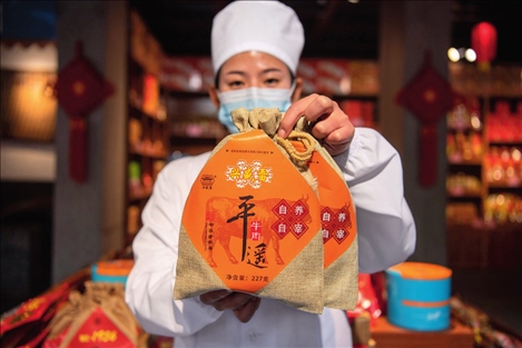 在位于山西省晉中市平遙縣的平遙古城南大街的一家平遙牛肉店內(nèi)，工作人員展示一款牛肉產(chǎn)品（資料照片）楊晨光攝 / 本刊