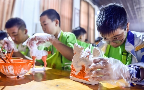 小朋友們?cè)诼尻柺忻辖騾^(qū)朝陽鎮(zhèn)南石山村體驗(yàn)唐三彩素胎施釉技藝。圖片來源：視覺中國