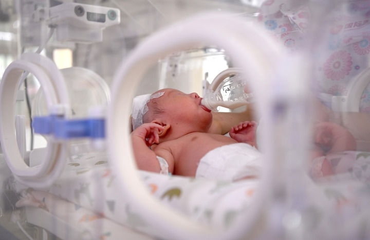 2024年6月1日，在西安國(guó)際醫(yī)學(xué)中心醫(yī)院新生兒科病房，護(hù)士為新生兒喂奶。 新華社記者 劉瀟 攝