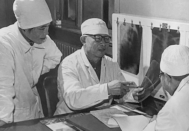 1980年1月16日，中日友好醫(yī)院首任院長(zhǎng)辛育齡（中）在內(nèi)蒙古結(jié)核病院與胸外科醫(yī)師討論病例（翻拍照片）。 新華社發(fā)