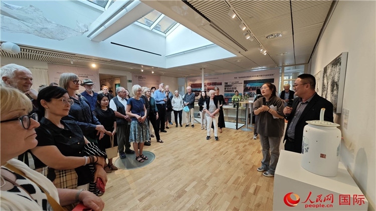 參展人、景德鎮(zhèn)陶瓷大學(xué)美術(shù)學(xué)院副院長(zhǎng)邵長(zhǎng)宗（右一）向來(lái)賓介紹參展作品。人民網(wǎng)記者 殷淼攝