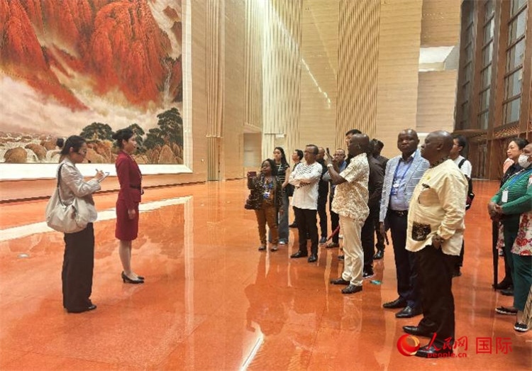 代表團(tuán)在入口處聽取講解。人民網(wǎng) 曹欣悅攝