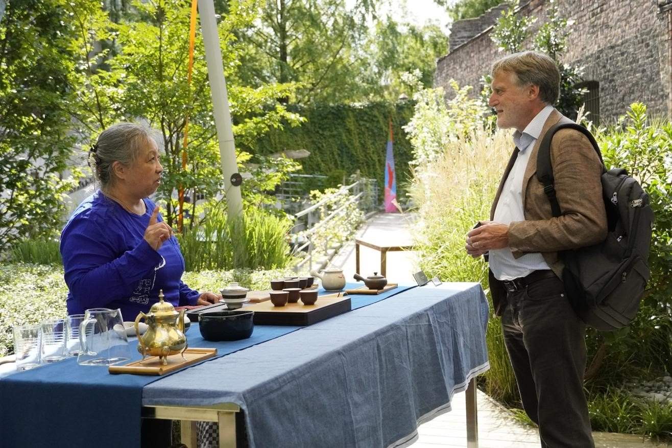 在博物館的戶外花園來賓品味中國茶藝。比利時維他命文化傳媒供圖