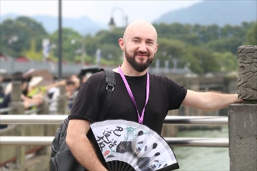 俄羅斯塔斯社執(zhí)行編輯葉夫根尼·扎多羅日內(nèi)在都江堰魚嘴拍照留念。（李佩藺 攝）