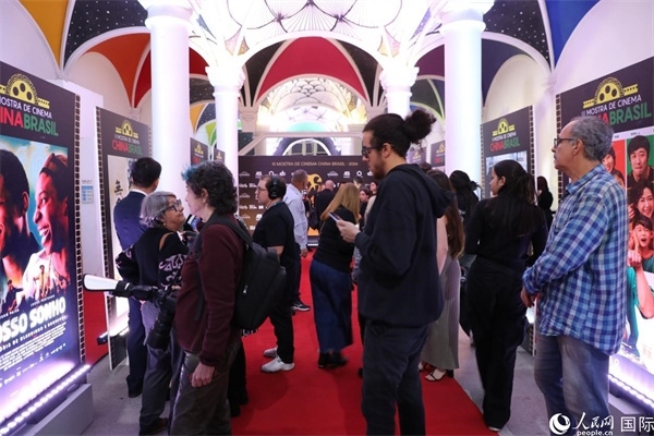為期4天的第三屆中國(guó)－巴西電影展期間，來自中巴兩國(guó)的14部參展影片受到巴西電影愛好者和社會(huì)各界人士好評(píng)，圖為當(dāng)?shù)赜^眾在影展舉辦地巴西里約熱內(nèi)盧勞拉—阿爾維姆文化之家的迎賓廳欣賞參展電影海報(bào)。 人民網(wǎng)記者 陳一鳴攝