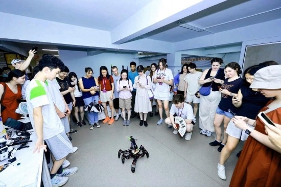 8月25日，中外青年在浙江杭州觀看機(jī)器人表演。新華社發(fā)（清華大學(xué)供圖）