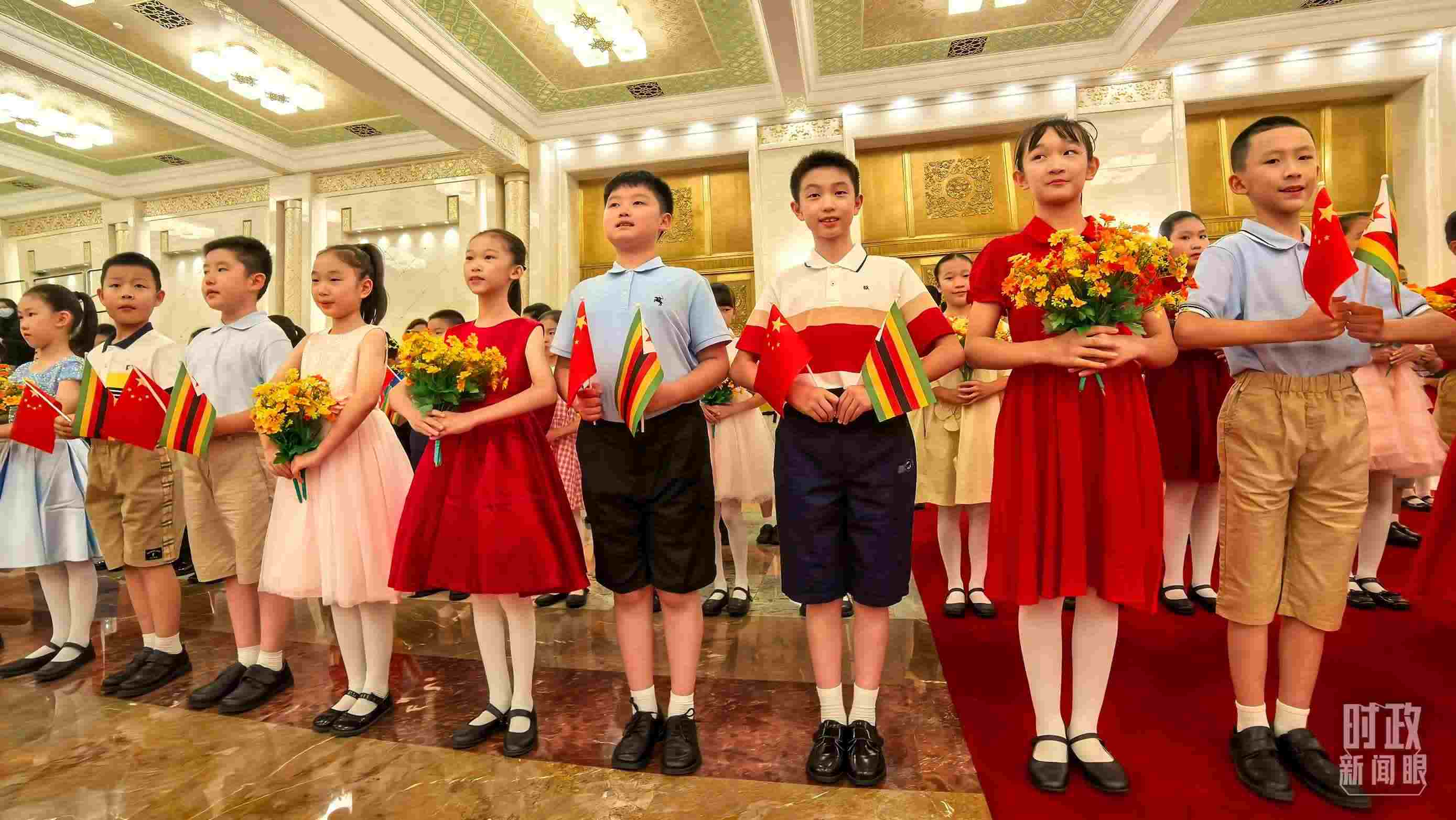 △現(xiàn)場歡迎津巴布韋總統(tǒng)訪華的青少年。（總臺(tái)央視記者鐘銳拍攝）