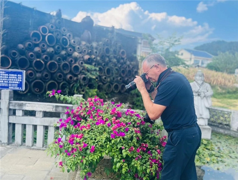 遠(yuǎn)處黔北民居錯(cuò)落有致，近處一只黑色的蝴蝶穿梭于粉紫色三角梅花叢間隙，與俄羅斯“大歐亞”總編輯弗拉基米爾·別列日內(nèi)赫的鏡頭玩起了捉迷藏，“你追我逃，不亦樂乎”。（張亞欣攝）